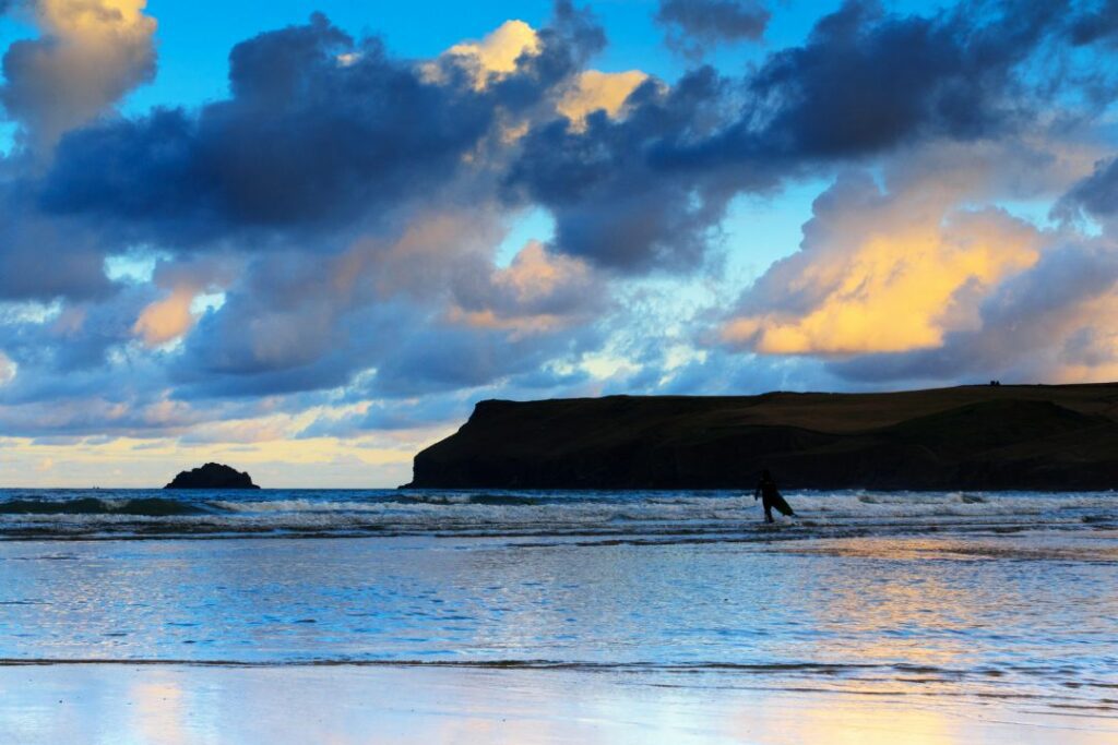 lone surfer about to paddle out for an evening session at Polzeath